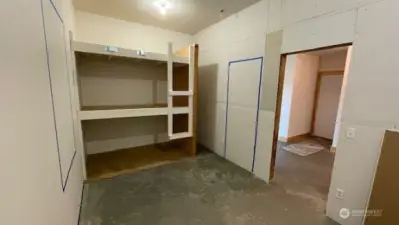 Blue tape shows approximate location of the framed door and windows in this roughed in space.