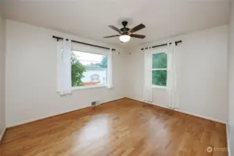 Upstairs bedroom #1 with hardwood floors and ceiling fan.