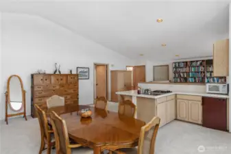 The door to the far right leads to the wrap-around deck, with a convenient half bath located just to its left in the photo.