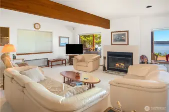 Cozy living room features a fireplace and large windows that frame captivating water views, bringing the beauty of the outdoors in.