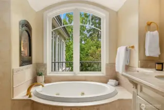 Jetted tub in master bathroom with built-in fireplace