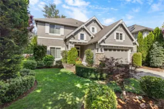 Manicured front yard framed by mature plantings.
