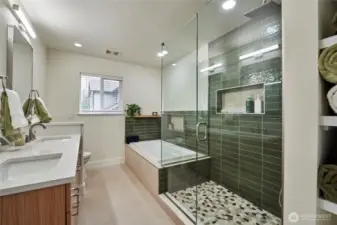 The spa inspired primary bathroom has been recently remodeled and offers dual vanities, a soaking tub, large shower enclosure with custom tilework and plenty of storage.