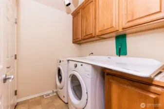 A dedicated laundry room with abundant storage cabinetry, full-size appliances, and a practical folding station—keeping daily routines organized and effortless.