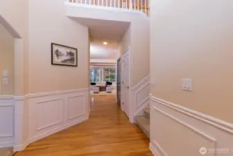 An elegant entry with detailed millwork, wainscoting, and hardwood floors leading into light-filled living spaces. The open sightline highlights the home’s generous scale and refined architectural details.