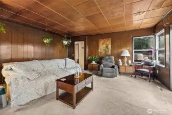 The stairs to the basement are located behind the couch.