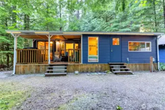 Full exterior view of park model with covered porch and addition