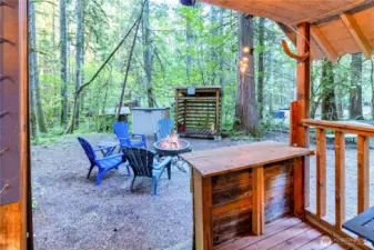 Bunkhouse covered porch view looking out to fire pit and wooded surroundings