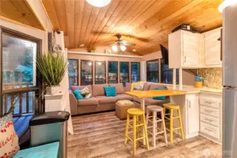 Open living area with sectional seating and kitchen with bar stools