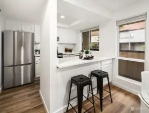 Kitchen with bar top seating and new quartz countertops.