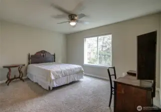 Lovely, spacious room has a ceiling fan and a comfortable, inviting space.