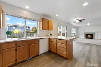 Cooking is a pleasure in the thoughtfully designed kitchen featuring all new quartz countertops, a new farm sink, and a ceramic tile backsplash for a modern touch. The space includes large bar seating with Quartz countertops, a pantry and freshly stained solid wood cabinets that add warmth and character. New laminate flooring enhances the kitchen with both style and low-maintenance care, making it as practical as it is beautiful.