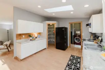 Kitchen with skylight, ample cabinetry, and counter space.