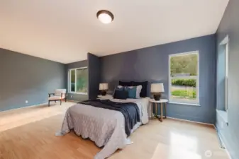 Primary bedroom with laminate flooring and bright natural light.