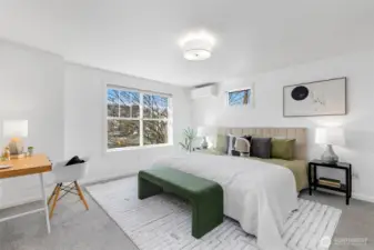 Spacious primary suite featuring abundant natural light (western exposure here as well) and a dedicated mini split system for efficient cooling during warmer months. King bed shown with plenty of additional space.