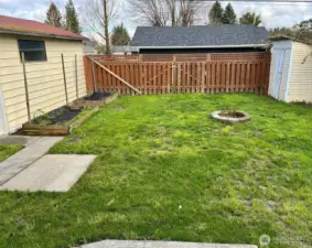 Backyard fully fenced with double gates to back alley. Garden shed.