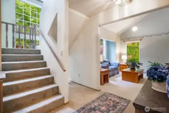 Staircase off entry with floor to ceiling windows floods the space with natural light