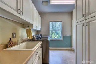 Utility room includes pull out ironing board and extra storage.