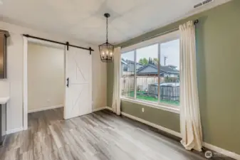 Dining area with windows overlooking backyard.