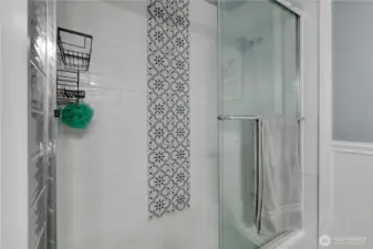 The tile details span into the bathtub (this has a tub & shower).