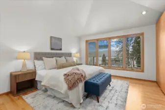 Primary bedroom with vaulted ceilings and view of the lake