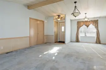 Living room facing front door and entry to primary, dining room upper right