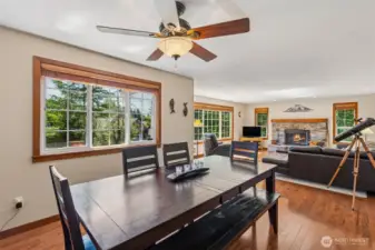 Large dining area has hardwood floors and a ceiling fan.