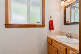 Half bath off the mud room also has a tile floor and countertop.