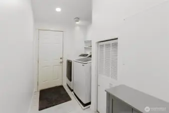 Laundry room with storage.  Door leads to attached 2 car garage and additional shop.