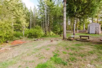 View of the backyard with fire pit and chicken coop.
