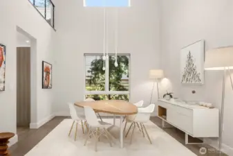 Dining space framed by double-height ceilings and sculptural lighting—simple, refined, and intentional.