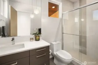 Additional bath with walk-in shower and streamlined, contemporary detailing.