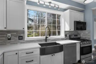 Farmhouse-style sink and large picture window bring charm and natural light to the kitchen.