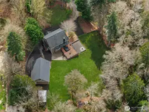 Overhead view highlights the home, detached shop, deck, and open yard space.