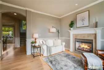 Second view of the living room.  Arched openings, hardwood floors, crown molding and wainscoting details.