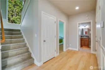 Main floor hallway with staircase to upper floor, nice width with large window for light.  Bedroom to the left, full bath that serves the main floor, double door closet to the right.