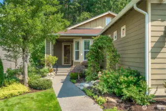 Beautiful mature landscaping welcomes you to the front porch. Notice the great storm door!