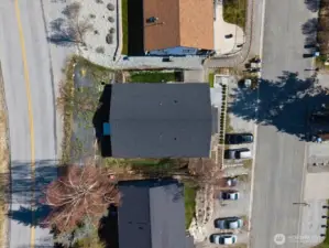 Aerial view of the property showing side yard and parking.