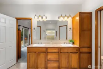 Primary bathroom with a wide double-sink vanity, large mirror, and overhead lighting, offering generous counter space and storage.