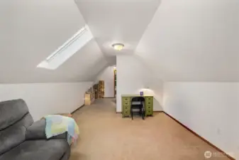 View of the upstairs bonus area showing a built-in workspace nook and shelving, offering a flexible area for reading, hobbies, or remote work.