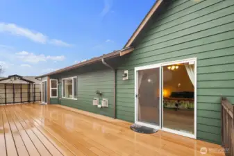 Large rear deck with sliding glass door access to the home, creating a seamless connection between indoor and outdoor living.