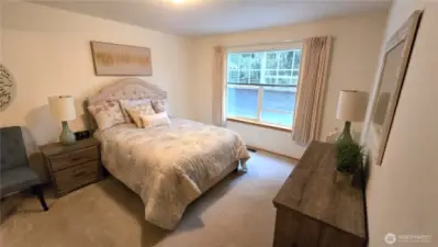 A spacious primary suit featuring a roomy bedroom, walk-in closet, walk-in shower & separate tub.