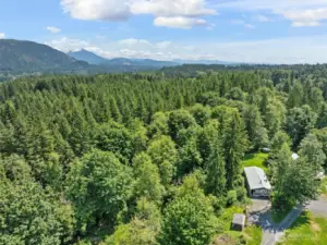 The wooded trails are to the left of the home.