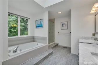 The primary bathroom window looks out to the green space beyond.