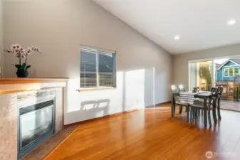 Gas fireplace next to kitchen and dining areas