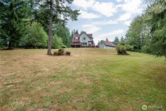 Stunning view of this statement Home setting atop the vast (2.4 acre) parcel and surrounding foliage