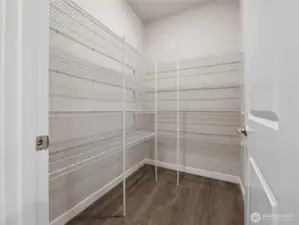 Walk-in pantry by garage entrance door.  Actual home is under construction and materials, colors, and finishes will vary. See site agent for details.