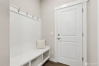 Built-in drop zone with bench shoe storage and coat hangers as you enter the home from the gagage.  Materials, colors, and finishes will vary. See site agent for details.