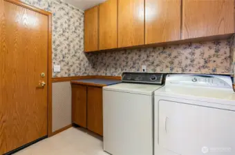 Laundry room / half bath with garage access door. Nice storage cupboards.