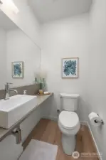 Photos of model home 9213 with similar finishes & floor plan. Even the powder room feels elevated. Modern fixtures, clean design, and just the right pop of personality.